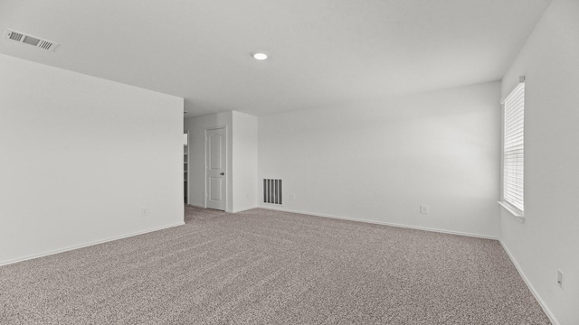 spare room featuring visible vents, baseboards, and carpet floors