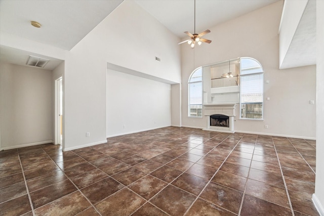 unfurnished living room with high vaulted ceiling and ceiling fan