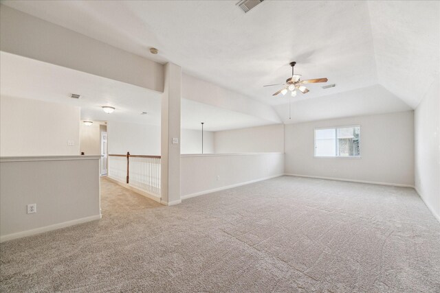 carpeted empty room with vaulted ceiling and ceiling fan