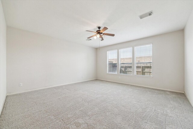 carpeted spare room with ceiling fan