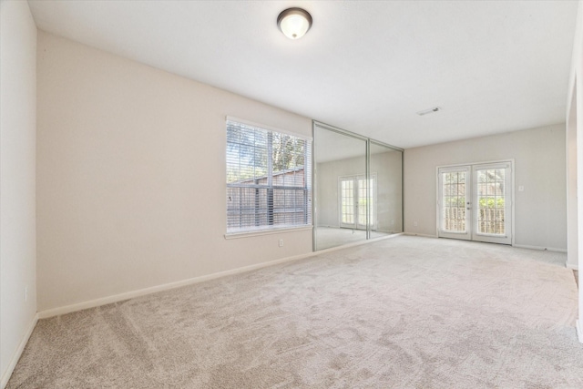 carpeted spare room with french doors