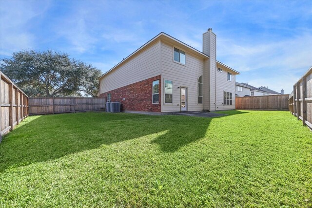 back of property featuring a yard and central air condition unit