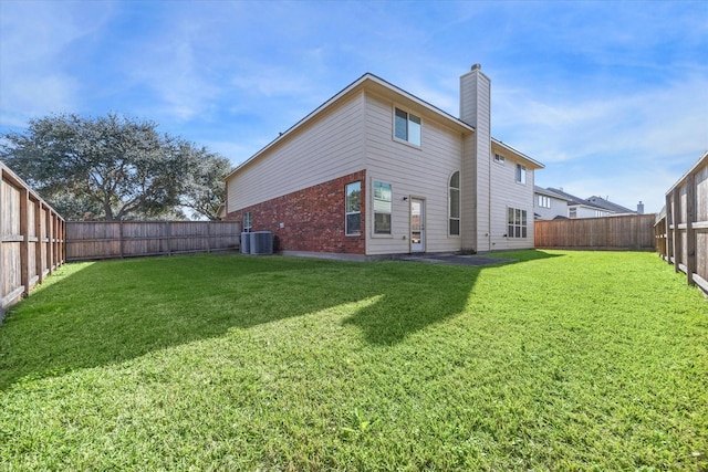 rear view of property featuring cooling unit and a yard