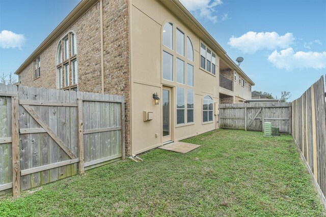 back of house featuring a lawn and central AC