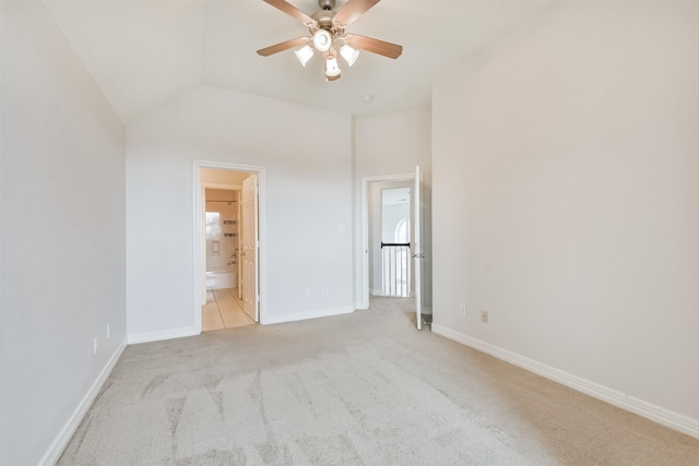 unfurnished bedroom featuring ensuite bath, ceiling fan, vaulted ceiling, and light colored carpet