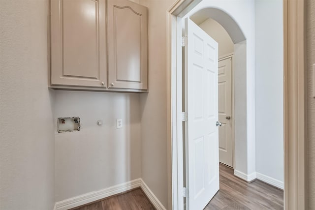 washroom with washer hookup, hardwood / wood-style flooring, and cabinets