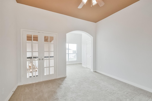 carpeted empty room featuring french doors and ceiling fan