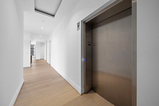 corridor featuring light hardwood / wood-style floors and elevator