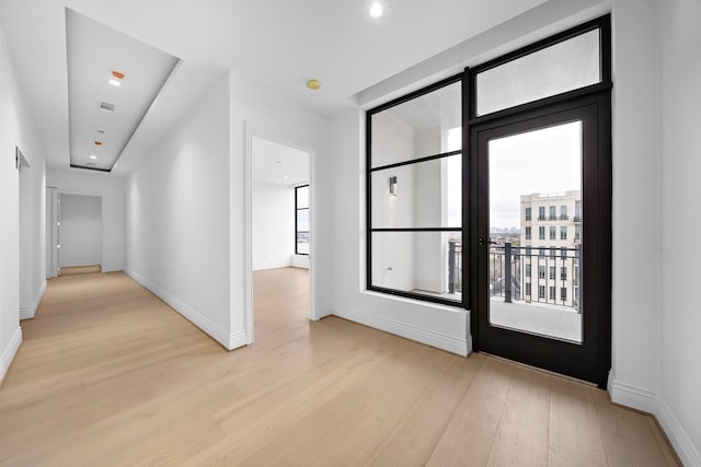 hall with a healthy amount of sunlight and light wood-type flooring