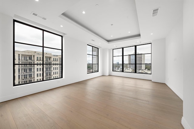 2323 San Felipe St Unit 803, Houston, TX 77019 - empty room featuring a raised ceiling and light wood-type flooring
