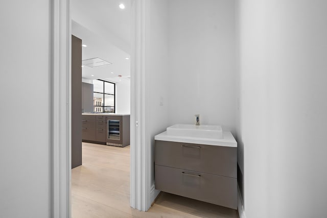 bathroom featuring hardwood / wood-style flooring, beverage cooler, and sink