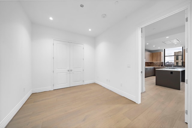 empty room with sink and light wood-type flooring