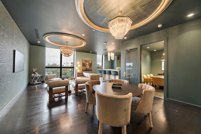 dining space with a tray ceiling, dark hardwood / wood-style floors, and an inviting chandelier