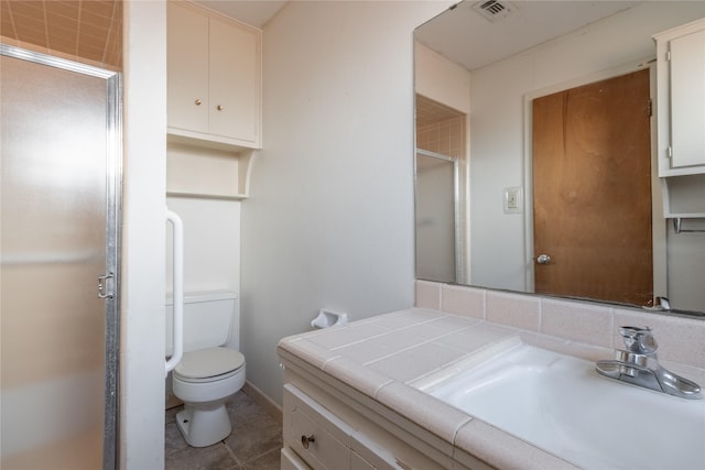 bathroom with vanity, toilet, and a shower with door