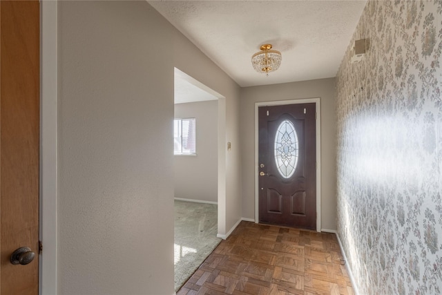 doorway featuring parquet flooring and a textured ceiling