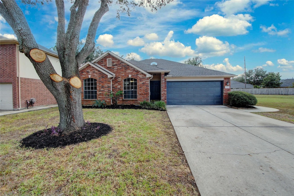 ranch-style home featuring a garage and a front lawn