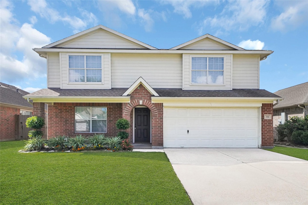 view of front of home with a front yard and a garage