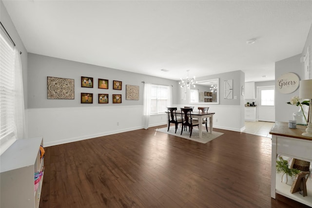 dining area featuring dark hardwood / wood-style flooring, a wealth of natural light, and a chandelier