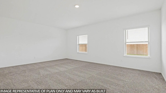 carpeted spare room featuring plenty of natural light