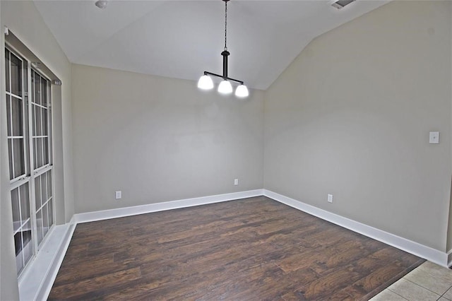 unfurnished dining area with a notable chandelier and vaulted ceiling