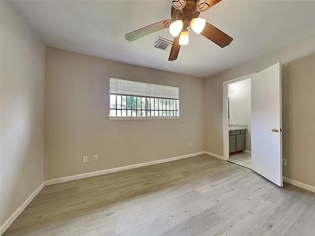 unfurnished bedroom with light wood-type flooring, ensuite bathroom, and ceiling fan