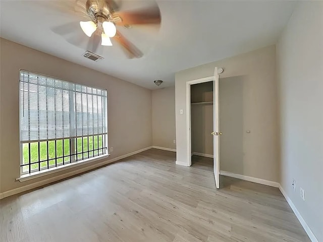 unfurnished bedroom featuring ceiling fan, light hardwood / wood-style floors, and a closet