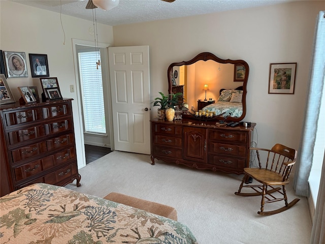 carpeted bedroom featuring a textured ceiling and ceiling fan