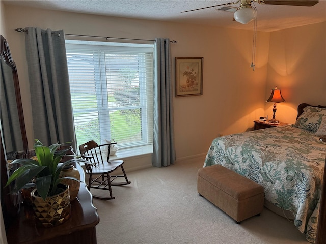 carpeted bedroom with ceiling fan and a textured ceiling