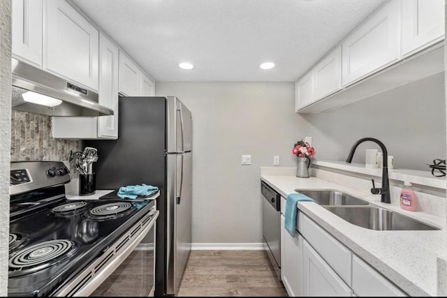 kitchen featuring sink, light stone counters, stainless steel appliances, and white cabinetry