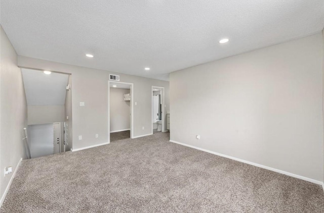 carpeted empty room featuring a textured ceiling