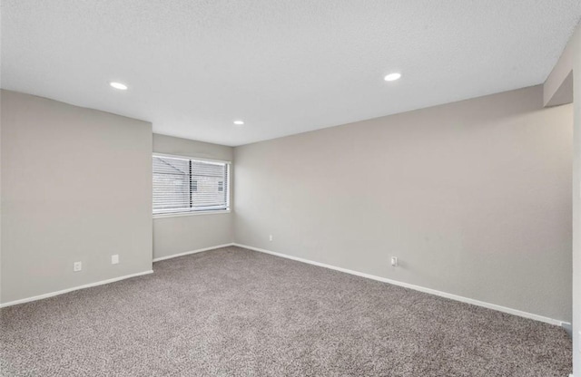 empty room with carpet floors and a textured ceiling