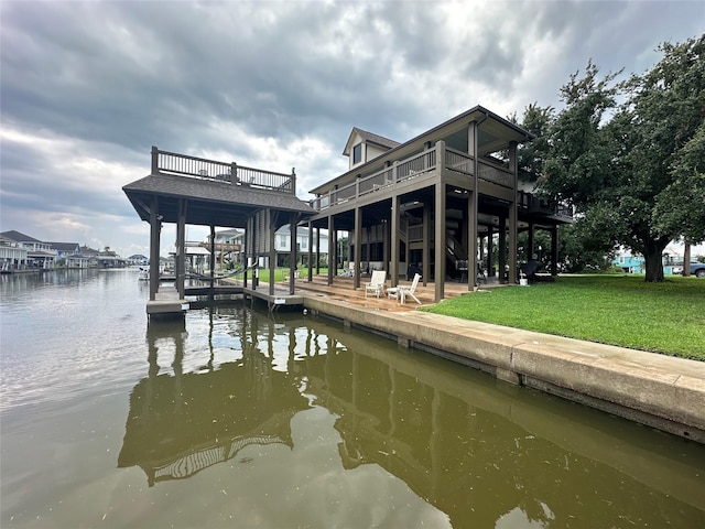 view of dock with a yard and a deck with water view