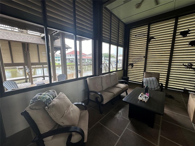 sunroom featuring a water view