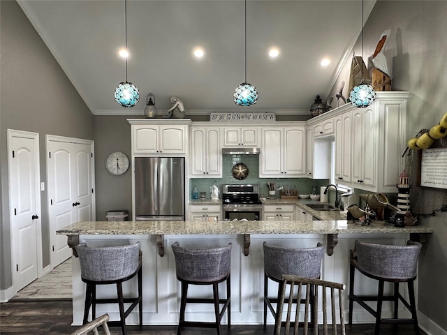 kitchen featuring appliances with stainless steel finishes, sink, decorative light fixtures, white cabinetry, and lofted ceiling