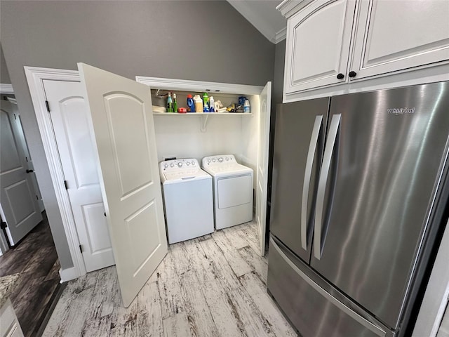 laundry room with light wood-type flooring, ornamental molding, and washing machine and clothes dryer