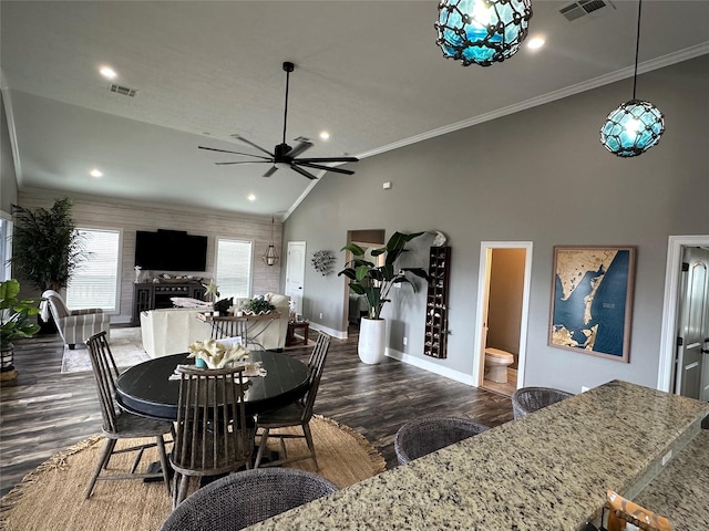 dining area with ceiling fan, dark wood-type flooring, vaulted ceiling, and ornamental molding