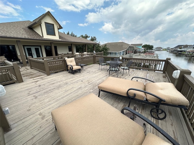 wooden terrace featuring french doors and a water view