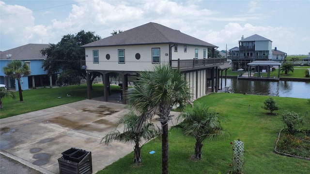 exterior space with a carport, a water view, and a lawn