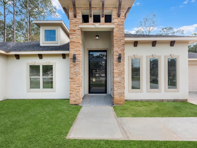 view of exterior entry featuring a lawn and a garage