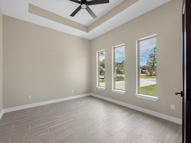 spare room featuring a tray ceiling and ceiling fan