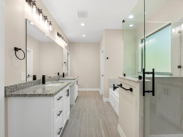 bathroom with vanity and separate shower and tub