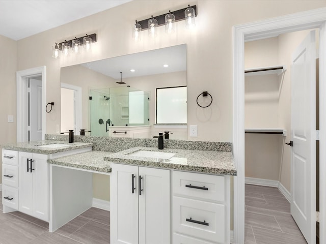 bathroom with vanity and a shower with door