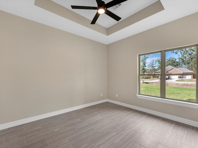 unfurnished room with a raised ceiling and ceiling fan