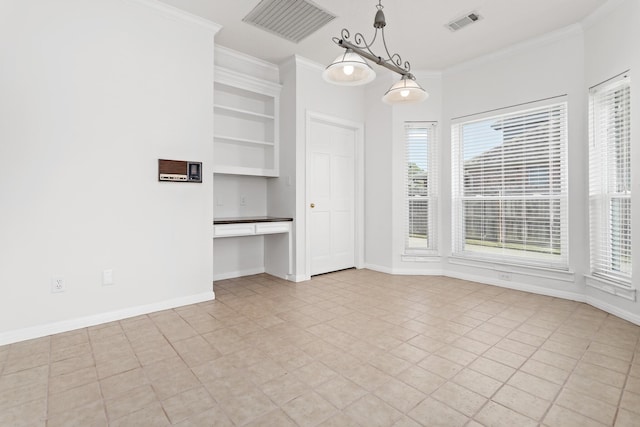 unfurnished dining area with a healthy amount of sunlight, built in desk, built in features, and ornamental molding