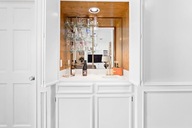 bar featuring white cabinetry and sink