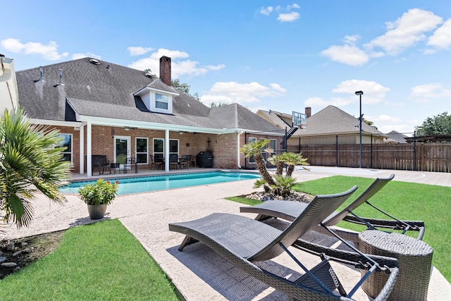 view of pool with a lawn and a patio