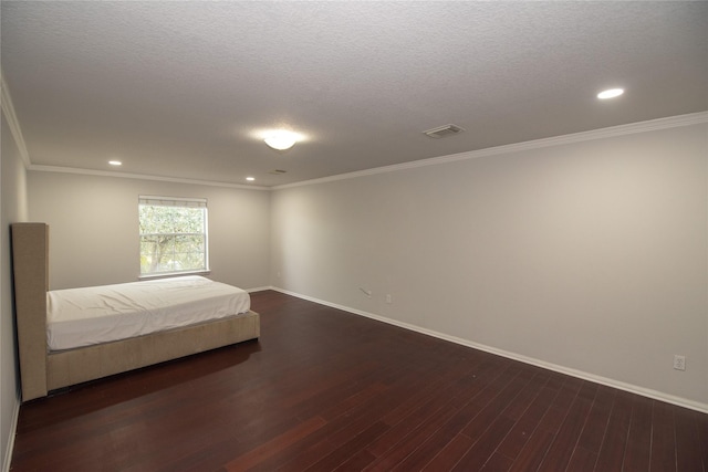 unfurnished bedroom with dark hardwood / wood-style floors, ornamental molding, and a textured ceiling