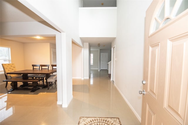 tiled entrance foyer with a towering ceiling