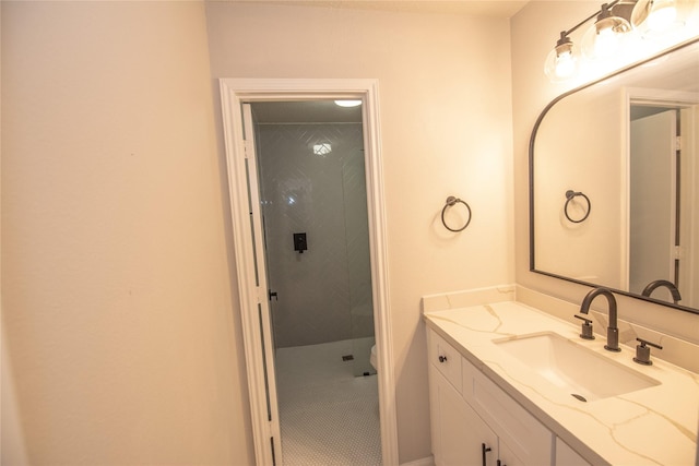 bathroom featuring tiled shower, tile patterned floors, vanity, and toilet