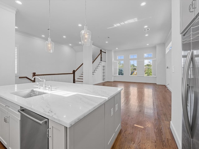 kitchen featuring a kitchen island, crown molding, stainless steel appliances, and white cabinets